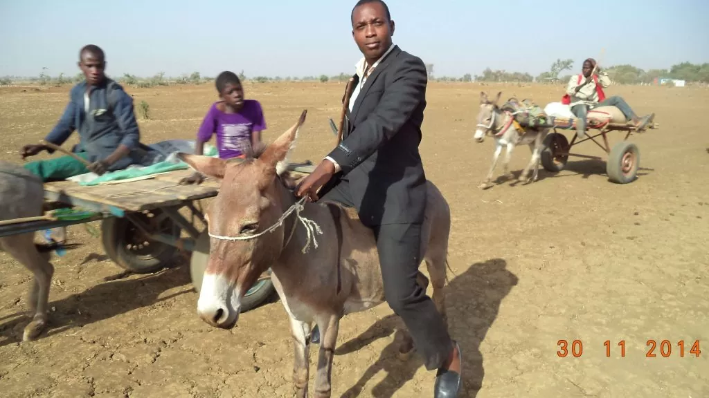 Gen. Coordinator riding on a Donkey in desert of Illela, Sokoto